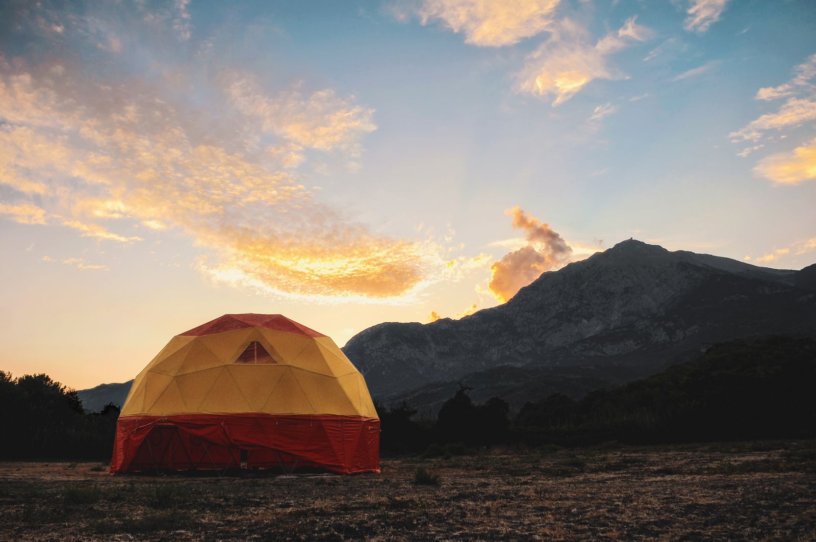 Dome tent at sunset with mountains behind